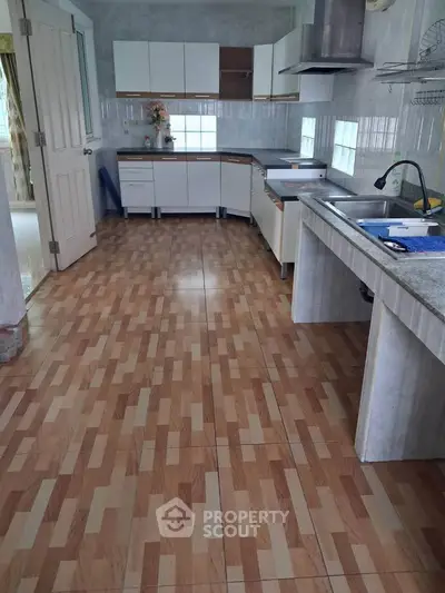 Spacious kitchen with modern cabinetry and ample counter space, perfect for culinary enthusiasts.