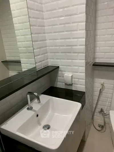 Modern bathroom with sleek white sink and stylish tile backsplash