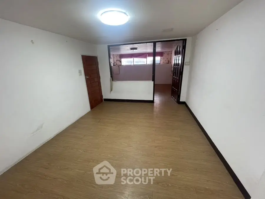 Spacious empty room with wooden flooring and bright lighting, ideal for customization.