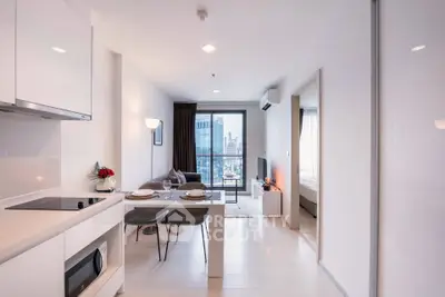 Modern open-plan living room with city view and sleek kitchen design.
