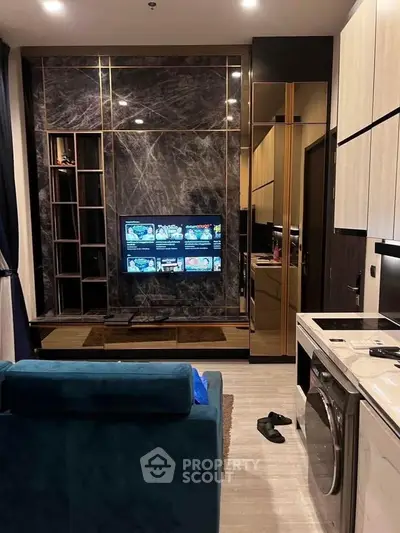 Modern living room with marble accent wall and built-in TV, featuring a sleek washing machine and stylish decor.