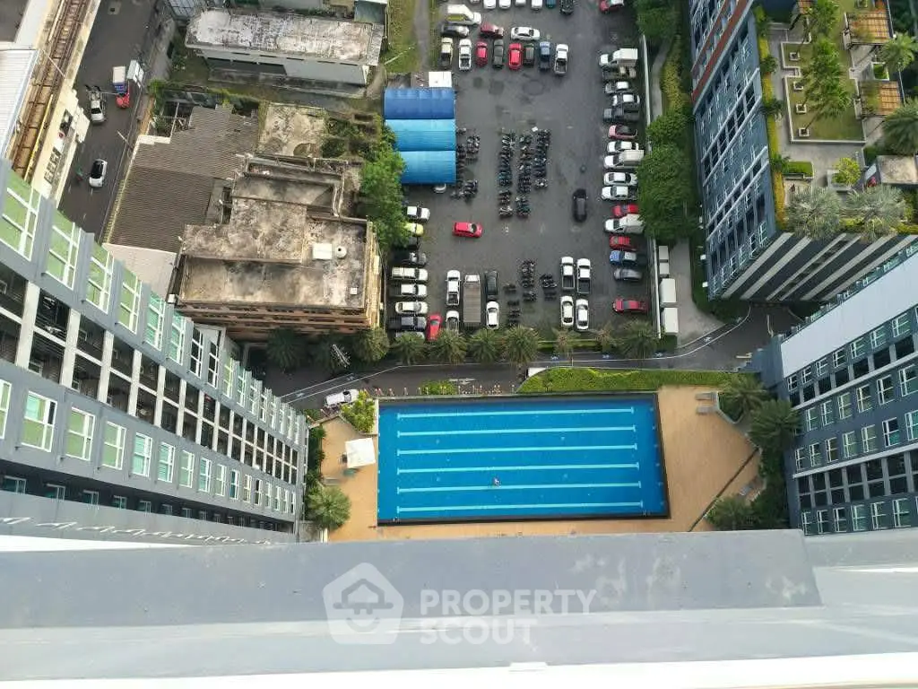 Stunning aerial view of modern apartment complex with swimming pool and parking area.