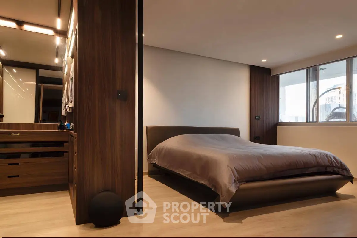 Modern bedroom with sleek design and large window offering city view