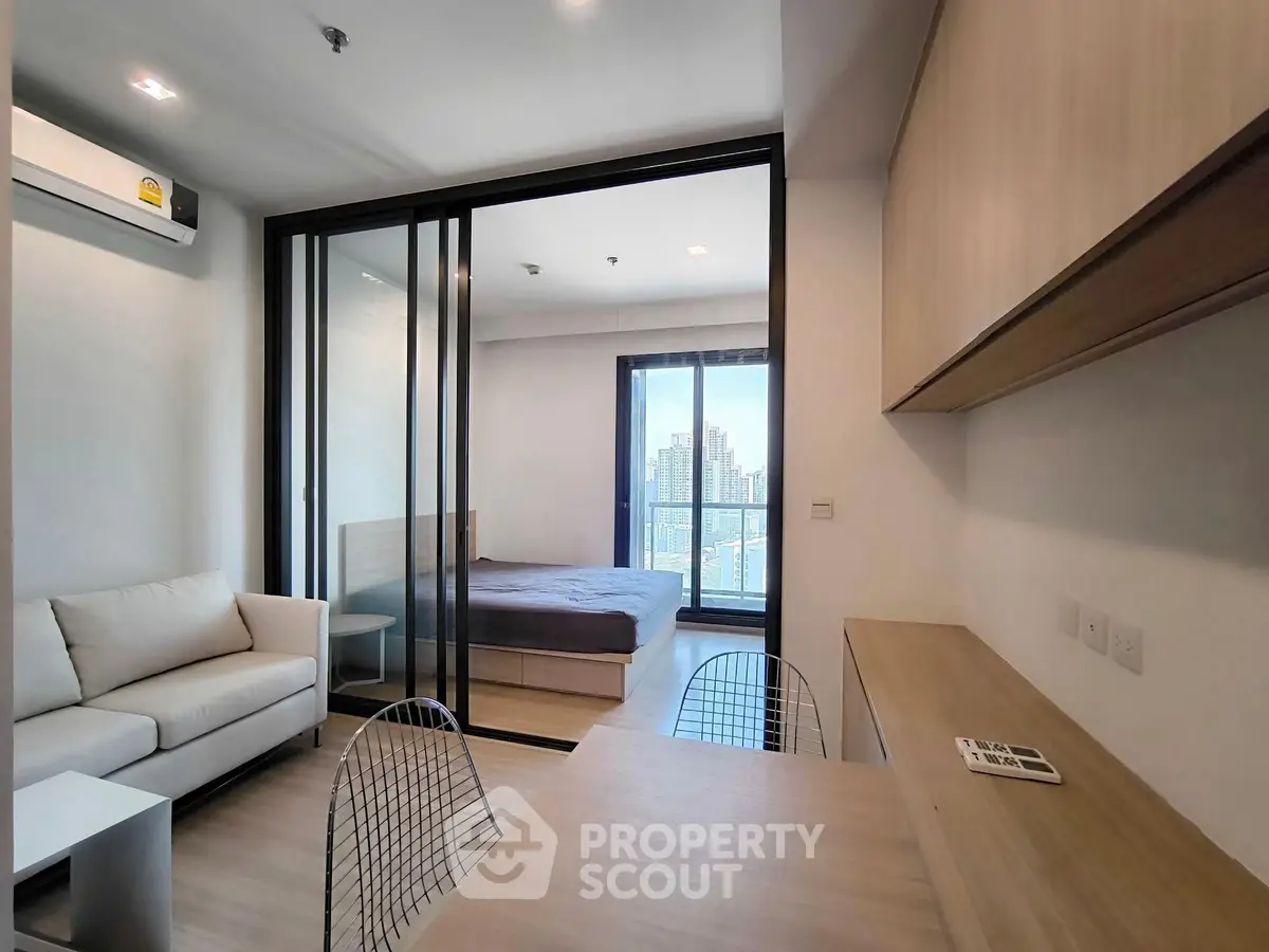 Modern apartment interior with open layout, featuring a cozy living room and bedroom with city view.