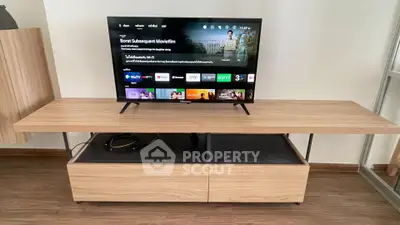 Modern living room with sleek wooden TV stand and flat-screen television, perfect for entertainment.