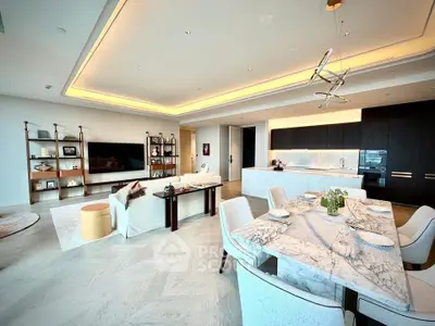 Luxurious open-plan living and dining area with modern kitchen in upscale apartment.