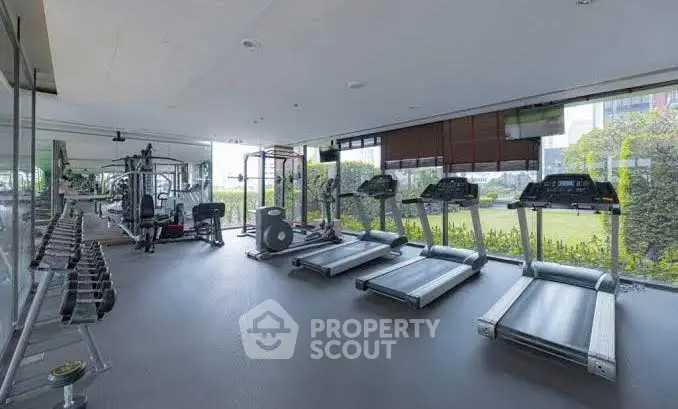 Spacious gym with modern equipment and garden view in luxury property
