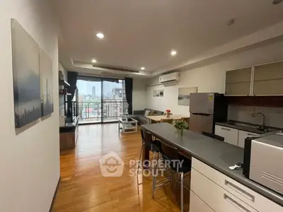 Modern open-plan living room and kitchen with balcony view in urban apartment