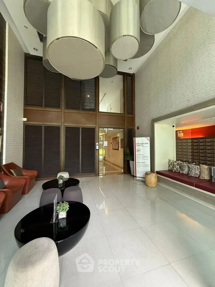 Luxurious lobby with modern seating and unique ceiling fixtures in upscale building.