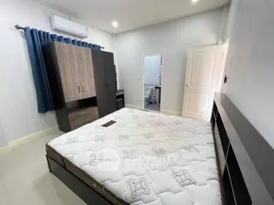Spacious bedroom with modern furniture and air conditioning in a stylish apartment.