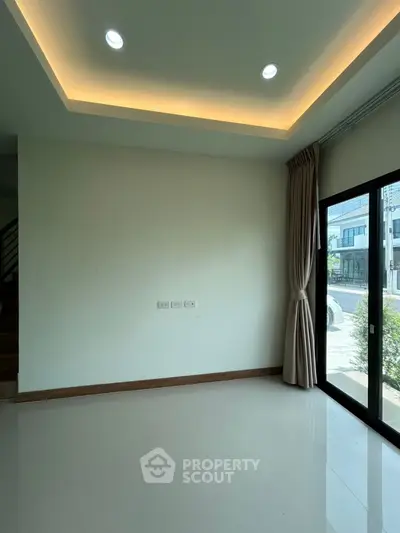 Modern empty room with recessed lighting and large window