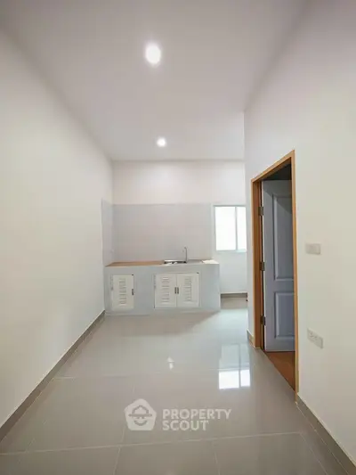 Minimalist kitchen with sleek design and ample natural light, featuring a compact layout and modern finishes.