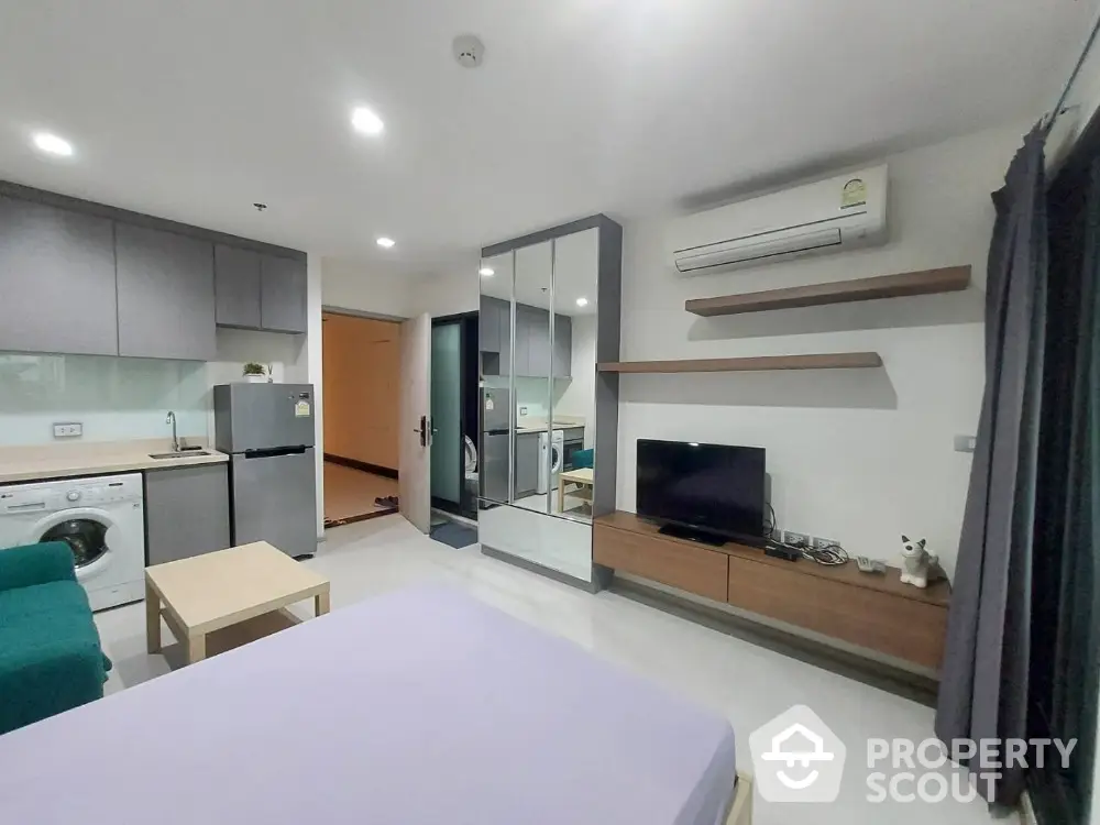 Modern studio apartment with open layout, featuring a cozy living area, compact kitchen, and stylish decor.