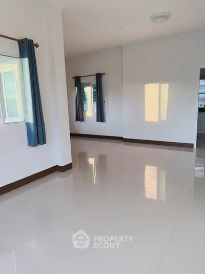 Spacious empty room with large windows and glossy tiled floor, perfect for customization.