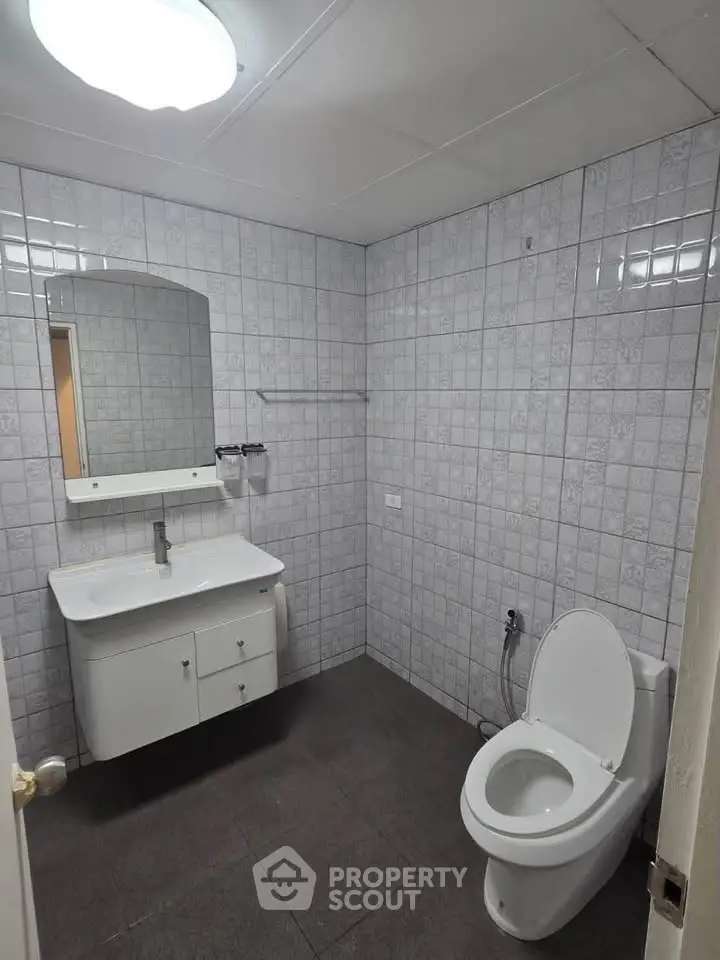 Spacious bathroom with modern fixtures and tiled walls, ideal for comfort and style.