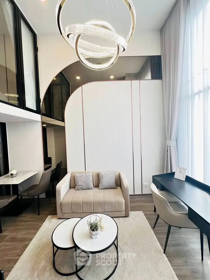 Modern living room with high ceiling and elegant chandelier in luxury apartment
