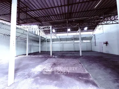 Spacious industrial warehouse with high ceilings and open floor plan, ideal for storage or manufacturing.