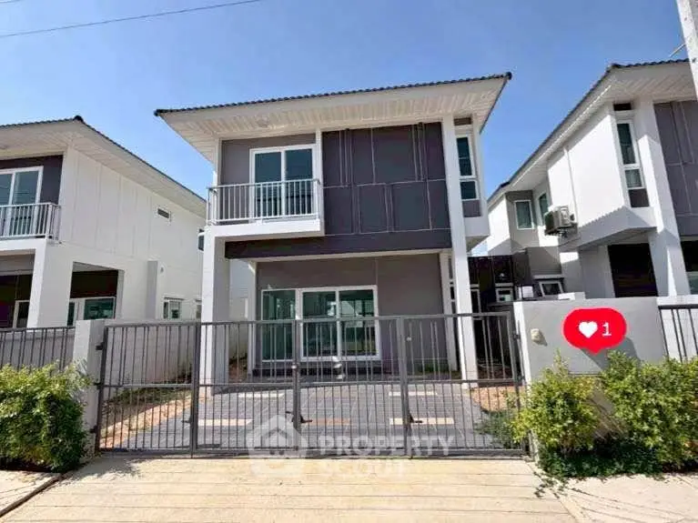 Modern two-story house with sleek design and gated entrance in a sunny neighborhood.