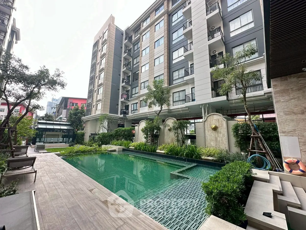 Luxurious residential building with serene pool and lush greenery