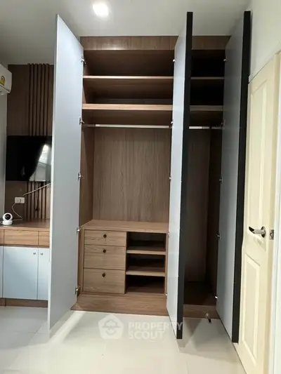 Spacious modern wardrobe with open doors in a stylish bedroom setting.