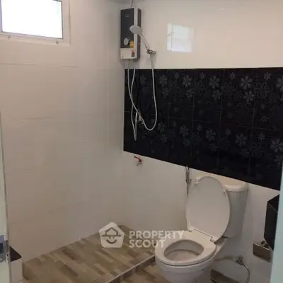 Modern bathroom with sleek shower and stylish black tile accent wall.