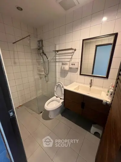 Modern bathroom with sleek fixtures and glass shower enclosure in a contemporary apartment.