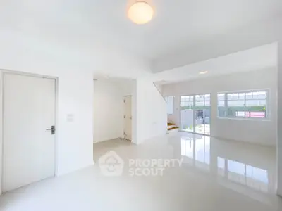 Spacious and bright living room with large windows and modern design, perfect for family gatherings.