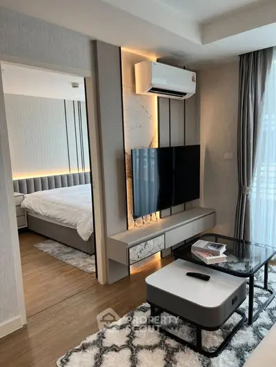 Modern living room with stylish decor and adjacent bedroom view