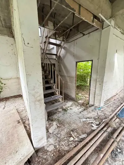 Explore potential in this fixer-upper with rustic charm and lush surroundings, perfect for creative renovation projects.