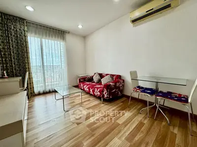 Modern living room with stylish decor and natural light, featuring a cozy sofa and glass dining table.