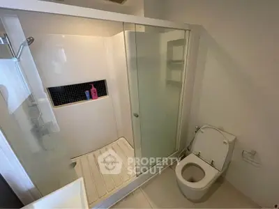 Modern bathroom with glass shower enclosure and sleek toilet design.