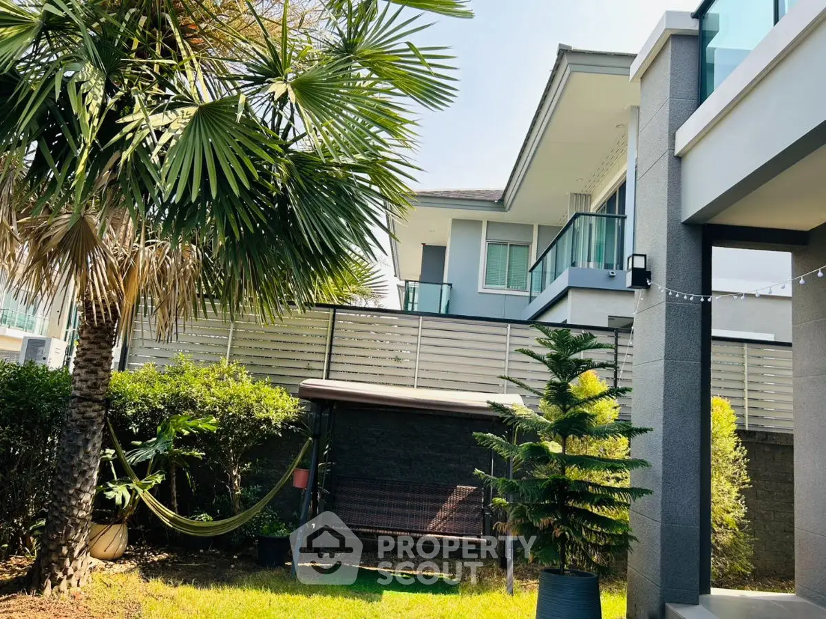 Luxurious modern home with lush garden and spacious balcony, perfect for relaxation and outdoor living.