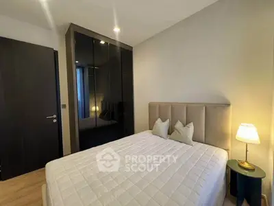 Modern bedroom with sleek black wardrobe and cozy lighting