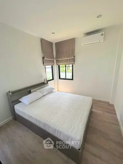 Modern minimalist bedroom with large windows and air conditioning