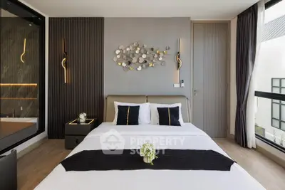 Luxurious modern bedroom with elegant decor and large windows offering natural light.