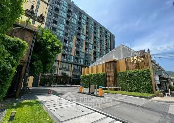 Modern condominium building with lush greenery and secure entrance in urban setting.