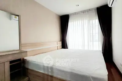 Cozy bedroom with natural light and modern furnishings in a stylish apartment.