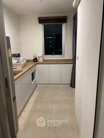 Modern kitchen with sleek cabinetry and window view, featuring a minimalist design and efficient layout.