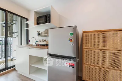 Modern kitchen with sleek fridge and microwave, open shelving, and balcony view.