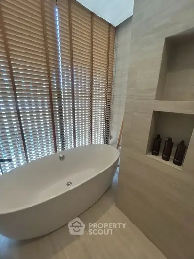 Luxurious bathroom with freestanding bathtub and elegant wooden blinds