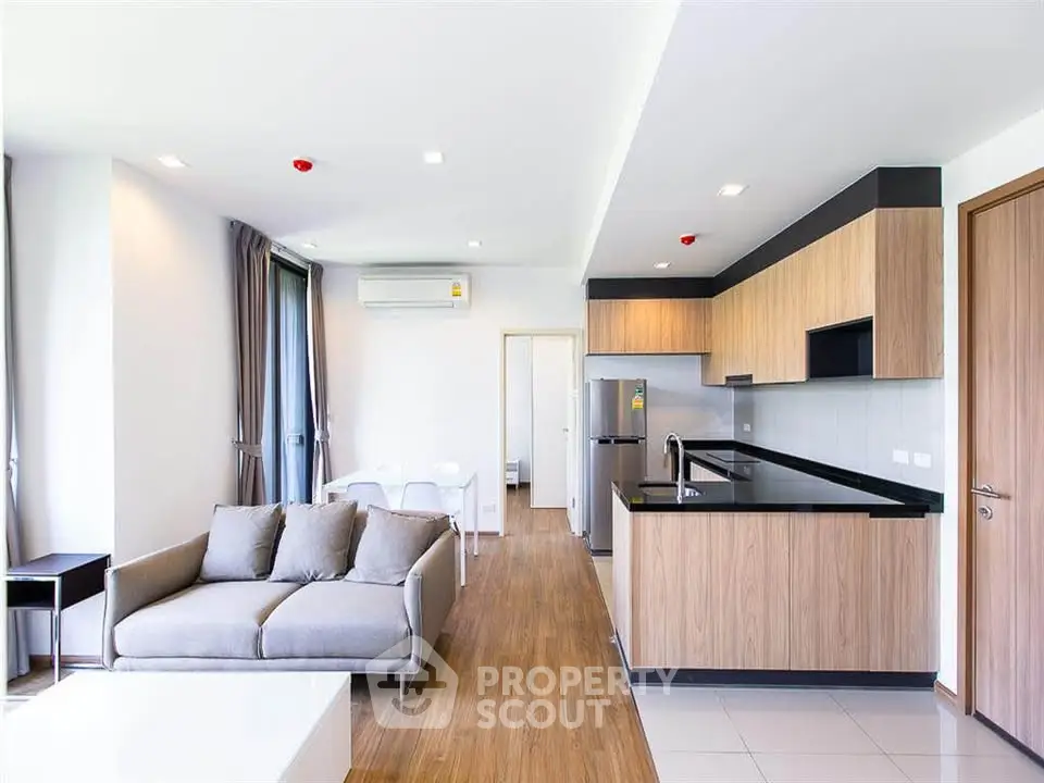 Modern open-plan living room and kitchen with sleek design and natural light.