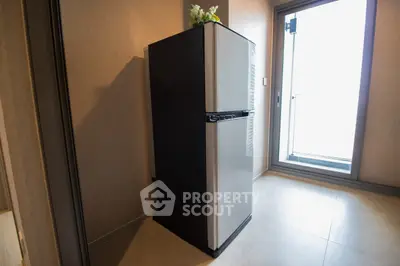Modern kitchen with sleek refrigerator and balcony view, perfect for urban living.