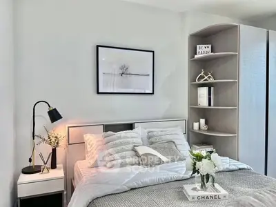 Modern bedroom with stylish decor and cozy ambiance, featuring elegant shelving and chic artwork.