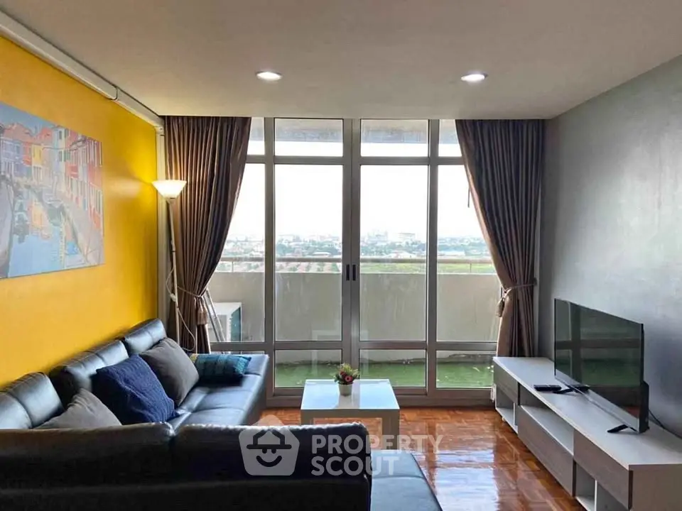 Spacious living room with modern decor and stunning city view balcony.