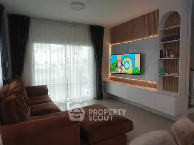 Modern living room with cozy brown sectional sofa and wall-mounted TV, featuring elegant curtains and ambient lighting.