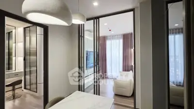 Modern apartment interior with stylish living room and dining area, featuring elegant lighting and floor-to-ceiling windows.