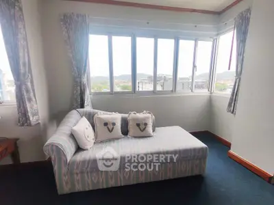 Bright living room with large windows and cozy sofa offering scenic views.