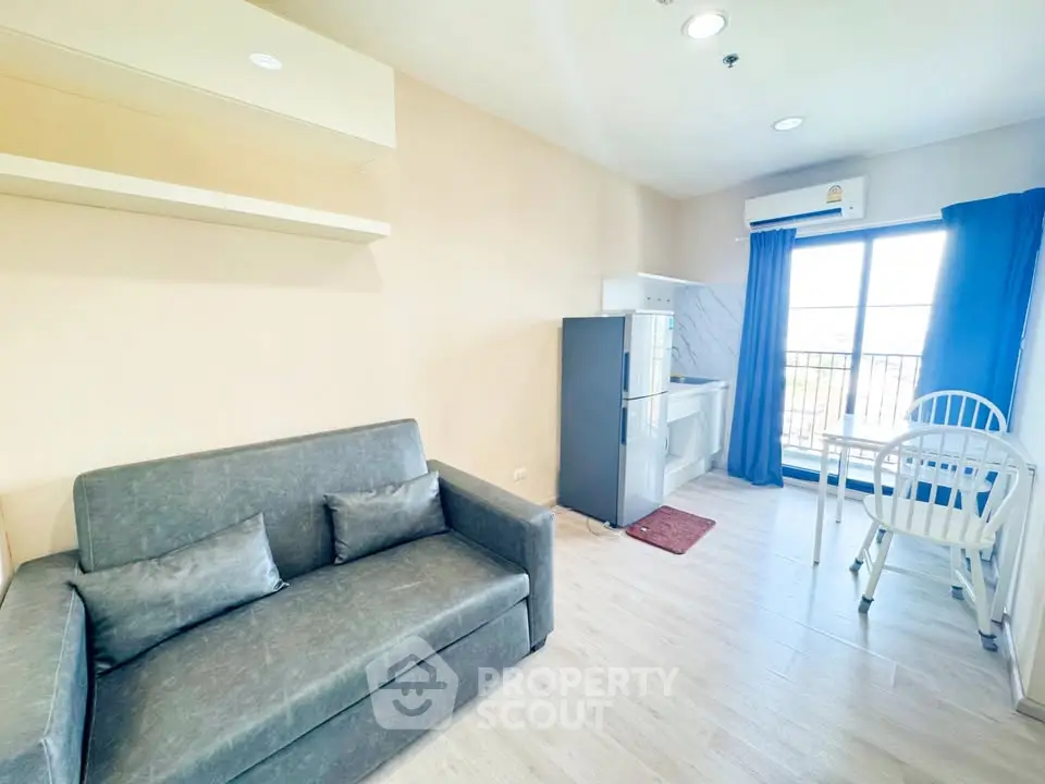 Bright modern living room with sofa, dining area, and balcony view in a stylish apartment.