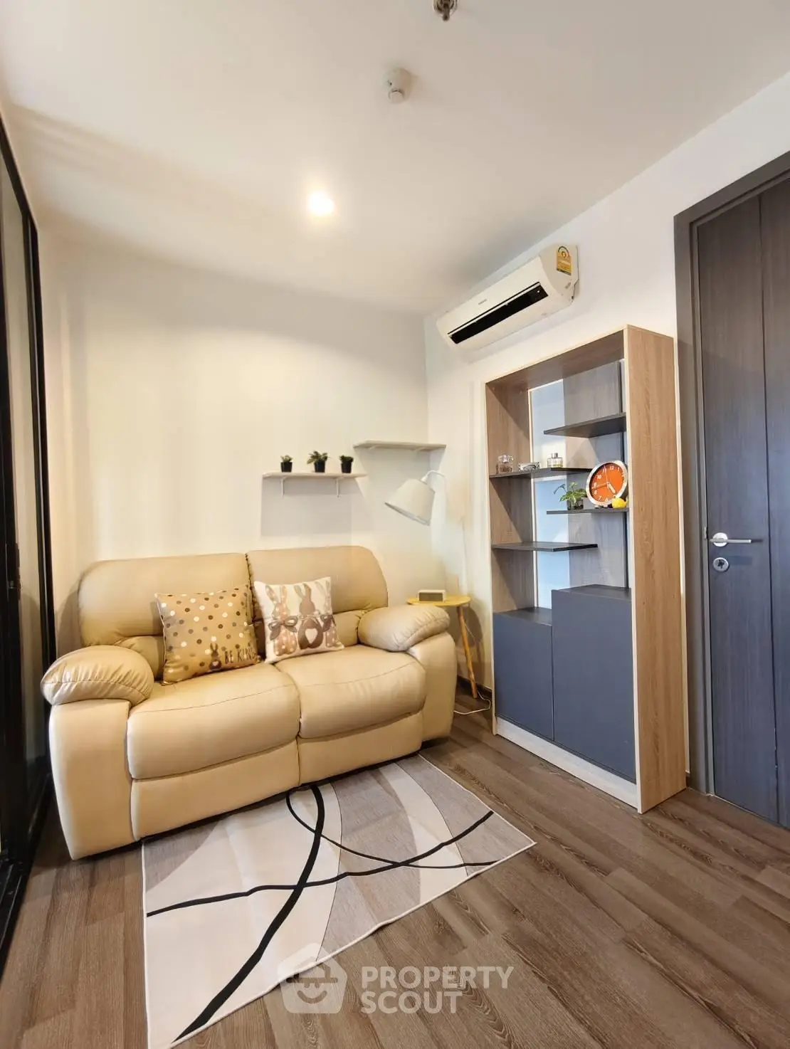 Cozy living room with modern decor and air conditioning, perfect for relaxation.