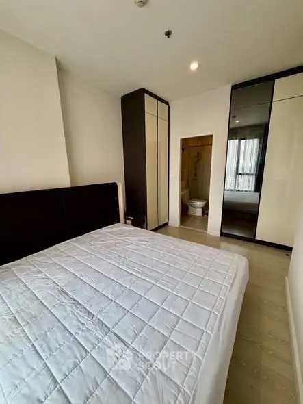 Modern bedroom with sleek wardrobe and cozy bed in a stylish apartment.